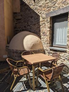 uma mesa e cadeiras em frente a um forno de pedra em Casa Rural El Mayadero em Zamora