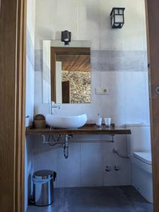 a bathroom with a sink and a mirror and a tub at Casa Rural El Mayadero in Zamora