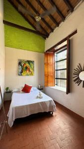 Un dormitorio con una cama con paredes verdes y una ventana en Maria Mulata Boutique Hotel en Santa Marta