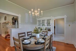 a dining room with a table with chairs and a chandelier at Rural Biggsville Vacation Rental with Porch 