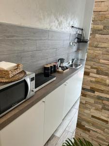 a kitchen with a microwave and a sink at Appartamento a Milano, 12 minuti dalla stazione centrale FS in Cinisello Balsamo