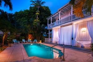 a swimming pool in front of a house at Coco Plum Inn in Key West