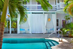 a house with a swimming pool in front of a house at Coco Plum Inn in Key West