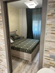 a reflection of a bedroom with a bed in a mirror at Appartamento a Milano, 12 minuti dalla stazione centrale FS in Cinisello Balsamo