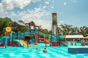 a water park with a water slide and people in it at Jellystone Park Tyler in Tyler