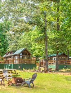 a group of chairs in a park with a log cabin at Jellystone Park Tyler in Tyler