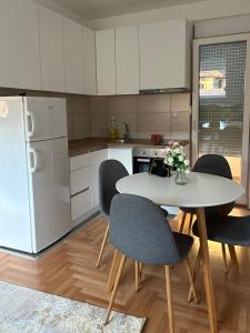 a kitchen with a table and chairs and a refrigerator at House Inn 2 in Pirot