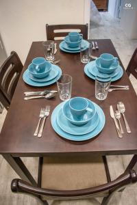 una mesa de madera con placas azules y cubiertos en Skyline Suites Grenada en Grand Anse