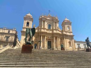 a large building with stairs in front of it at Mandorlo Barocco in Noto