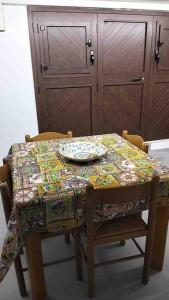 a dining room table with a tablecloth on it with two chairs at Mandorlo Barocco in Noto