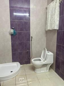 a bathroom with a toilet and a sink and a shower at Holiday apartment in Makkah