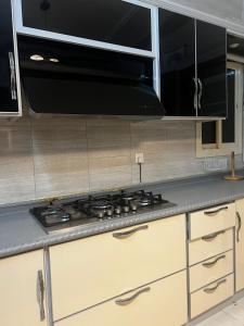a kitchen with a stove and a microwave at Holiday apartment in Makkah