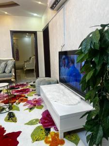 a living room with a flat screen tv on a rug at Holiday apartment in Makkah