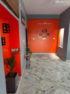 an empty hallway with orange walls and plants at Gharana in Udaipur