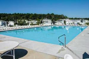 a large blue swimming pool with tables and chairs at Bay-View Beauty in Assateague Point in Berlin