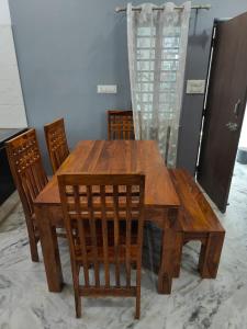 a wooden dining room table with chairs and a table at Gharana in Udaipur