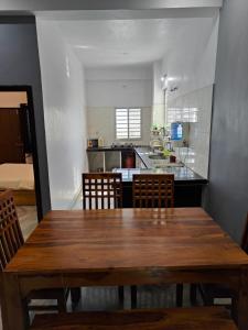 a dining room table with chairs and a kitchen at Gharana in Udaipur