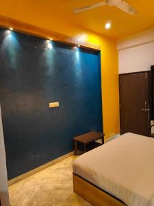 a bedroom with a blue wall with a bed and a table at Gharana in Udaipur