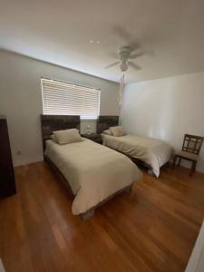 1 dormitorio con 2 camas y ventilador de techo en Your Holiday Home in Sunshine Coast, en Roberts Creek