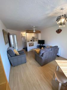 a living room with two couches and a table at Cardiff Bay Apartment in Cardiff