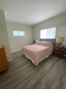 1 dormitorio con 1 cama y suelo de madera en Your Holiday Home in Sunshine Coast, en Roberts Creek
