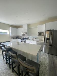 cocina grande con encimera blanca grande y sillas en Your Holiday Home in Sunshine Coast, en Roberts Creek