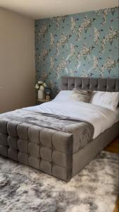 1 dormitorio con 1 cama grande y pared azul en Harborne House en Birmingham
