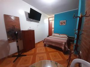 a small room with a bed and a tv in it at Nasca Trails B&B in Nazca