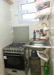 a kitchen with a sink and a stove at Furnished Apartment in Minya