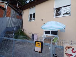 a patio with a blue and white umbrella and chairs at Sobe Kata - atomska banja Gornja Trepca in Čačak