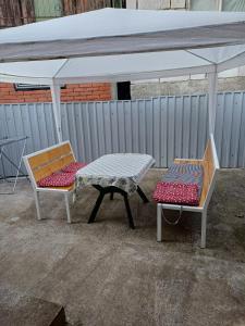 una mesa de picnic y dos sillas bajo una tienda en Sobe Kata - atomska banja Gornja Trepca, en Čačak