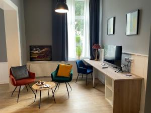 a room with a desk with chairs and a television at Hotel Alte Navigationsschule in Rhauderfehn