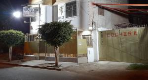 a building with a fence and a tree in front of it at Nasca Trails B&B in Nazca