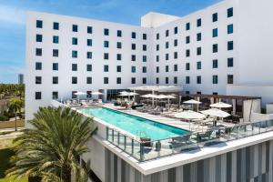 une image d'un hôtel avec un billard, des tables et des parasols dans l'établissement AC Hotel by Marriott Miami Aventura, à Aventura