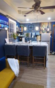 una cocina con paredes azules y una gran isla con sillas azules en Chans Lakeside Hideaway, en Stone Mountain