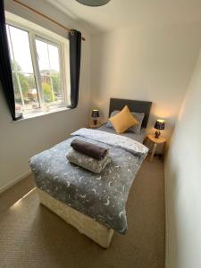 1 dormitorio con cama con almohadas y ventana en Cardiff Bay Apartment, en Cardiff