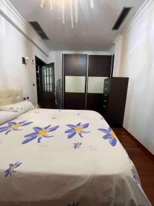 een slaapkamer met een groot bed met blauwe bloemen erop bij Edjon Apartments in Tirana