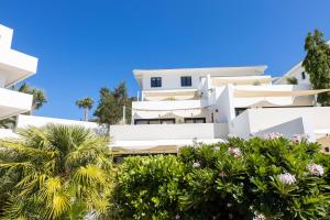 Dorp Sint Michiel的住宿－Green View at Blue Bay Golf & Beach Resort，一座白色的建筑,前面有棕榈树