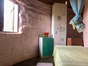 Zimmer mit einem grünen Kühlschrank und einem Fenster in der Unterkunft Espaço Ajna in Alto Paraíso de Goiás