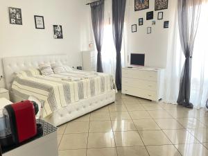 een witte slaapkamer met een bed en een televisie bij Garcia Guest House in Verona