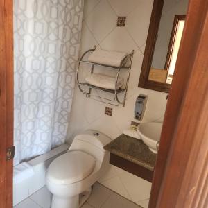 a bathroom with a white toilet and a sink at Hotel Bella Casona in Riobamba