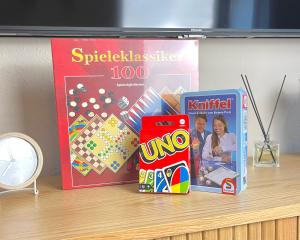 - une table avec un livre, un jeu de société et un magazine dans l'établissement Ferienwohnung Tiefenbach mit Garten, à Oberstdorf