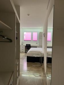 マドリードにあるファンウェイ アカデミック リゾートのベッドルーム1室(ベッド1台、窓2つ付)