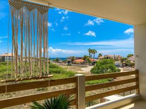 uma vista a partir da varanda de uma casa com uma grande janela em Isla penthouse & garden apartments Bonaire em Kralendijk