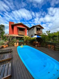 a swimming pool on the deck of a house at Residencial Vila Suel in Praia do Rosa