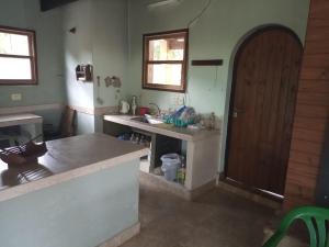 cocina con fregadero y puerta de madera en La Chona en Vaqueros