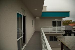 - Balcón de un edificio con mesa y ventana en Aloha Bratz Apartments 5, en Palhoça