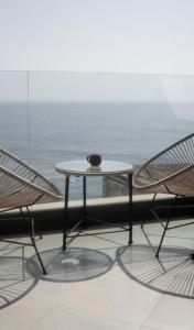 duas cadeiras e uma mesa em frente a uma janela em Oceana Surf Camp em Taghazout