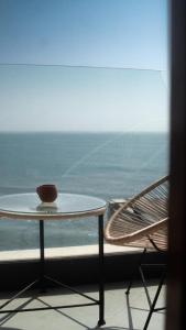 a table and a chair sitting next to a window at Oceana Surf Camp in Taghazout