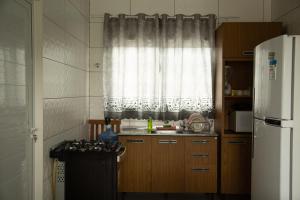 een keuken met een raam, een wastafel en een fornuis bij 5- OHANA - Aloha Bratz Apartments in Palhoça